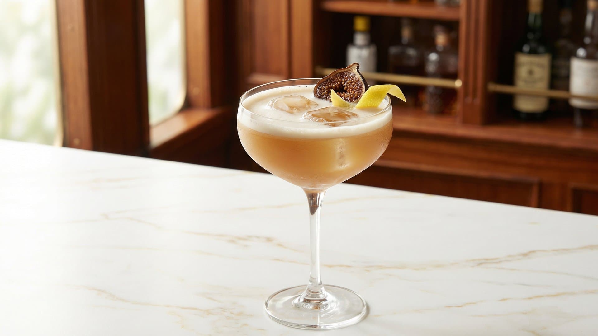 Temporal Extraction cocktail in a coupe garnished with Dehydrated fig slice and expressed lemon zest