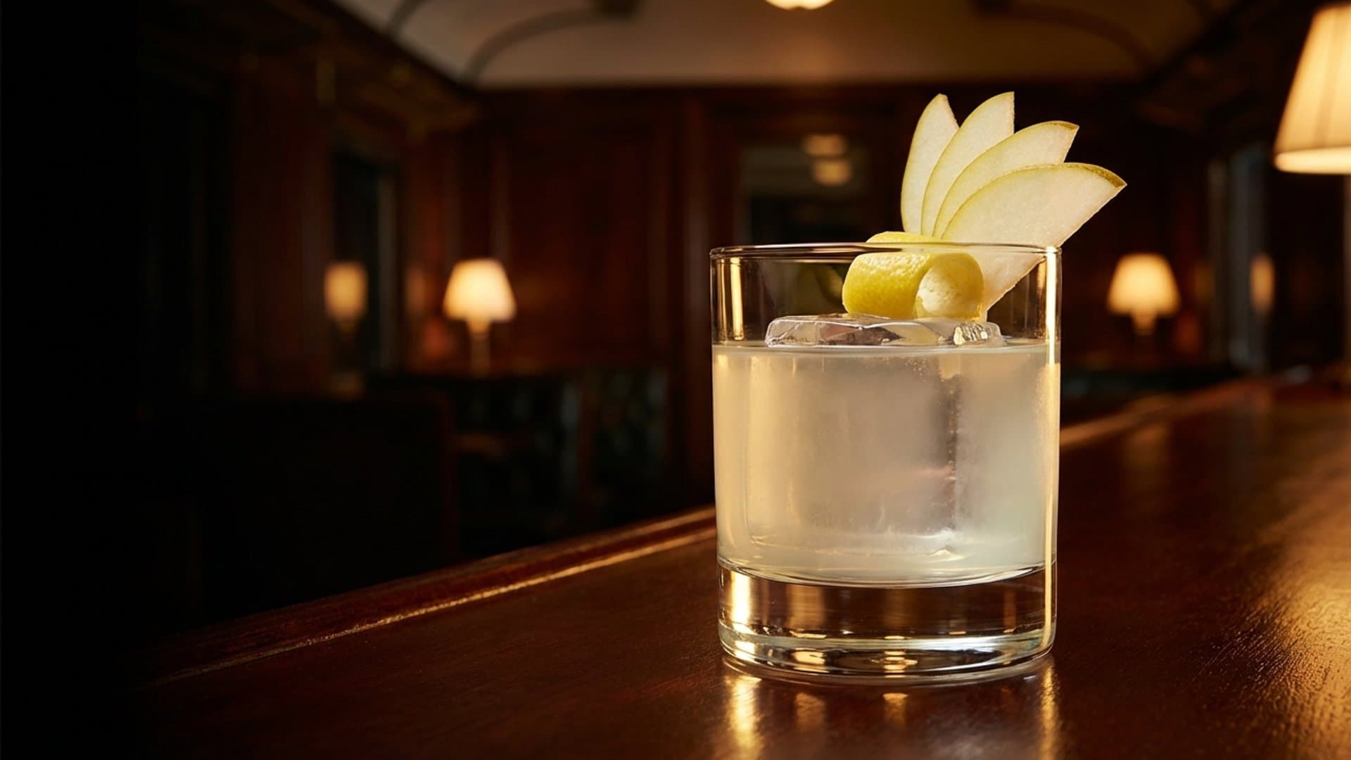 Clarified Autumn Reverie cocktail in a rocks garnished with expressed lemon peel and thin pear slice