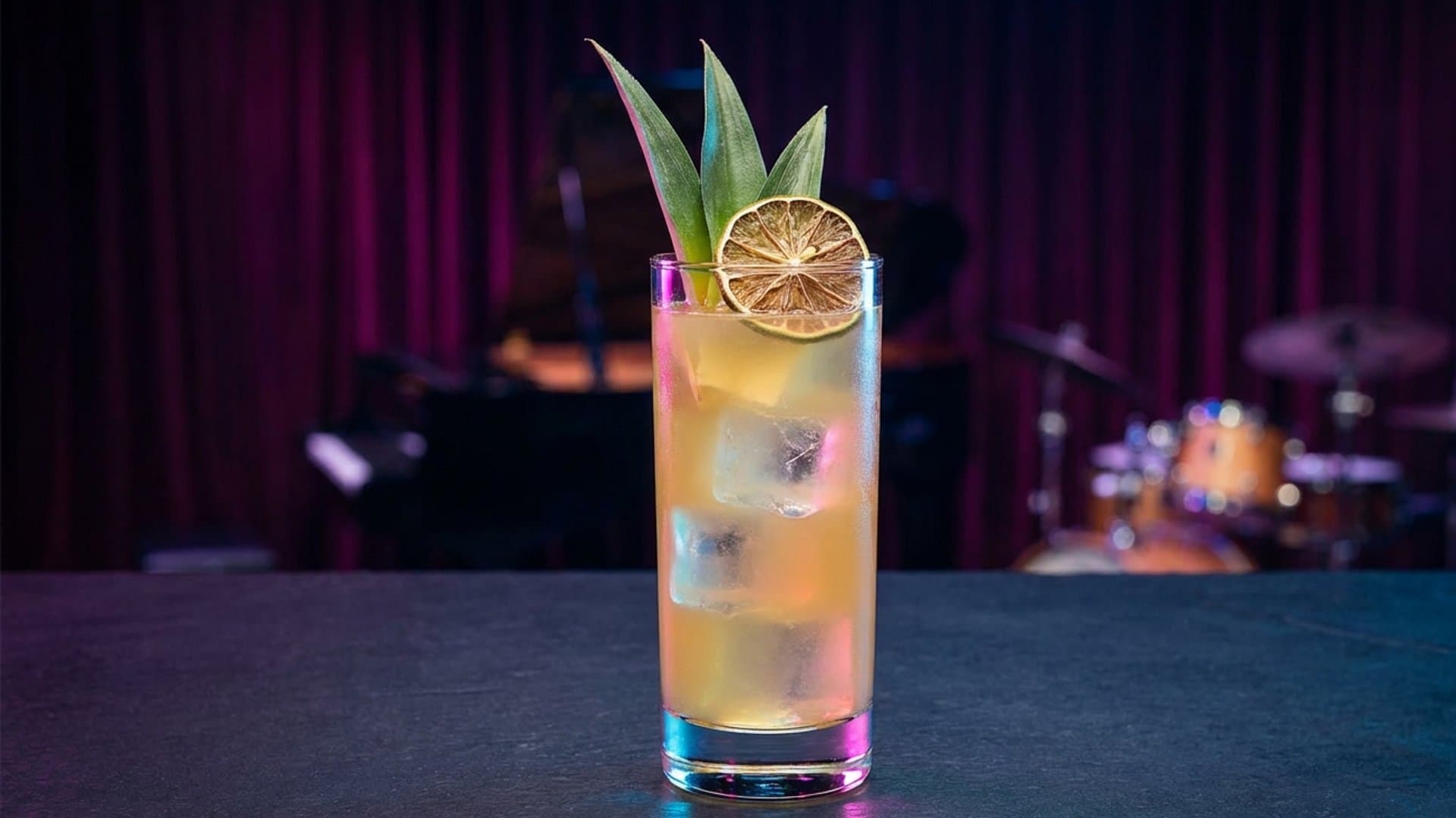 Cultura Viva cocktail in a Collins garnished with Pineapple fronds and dehydrated lime wheel