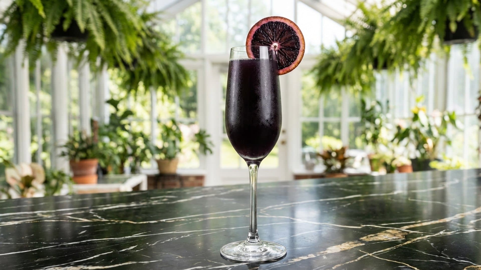 Sanguine Spring cocktail in a Champagne flute garnished with Blood orange wheel on the rim