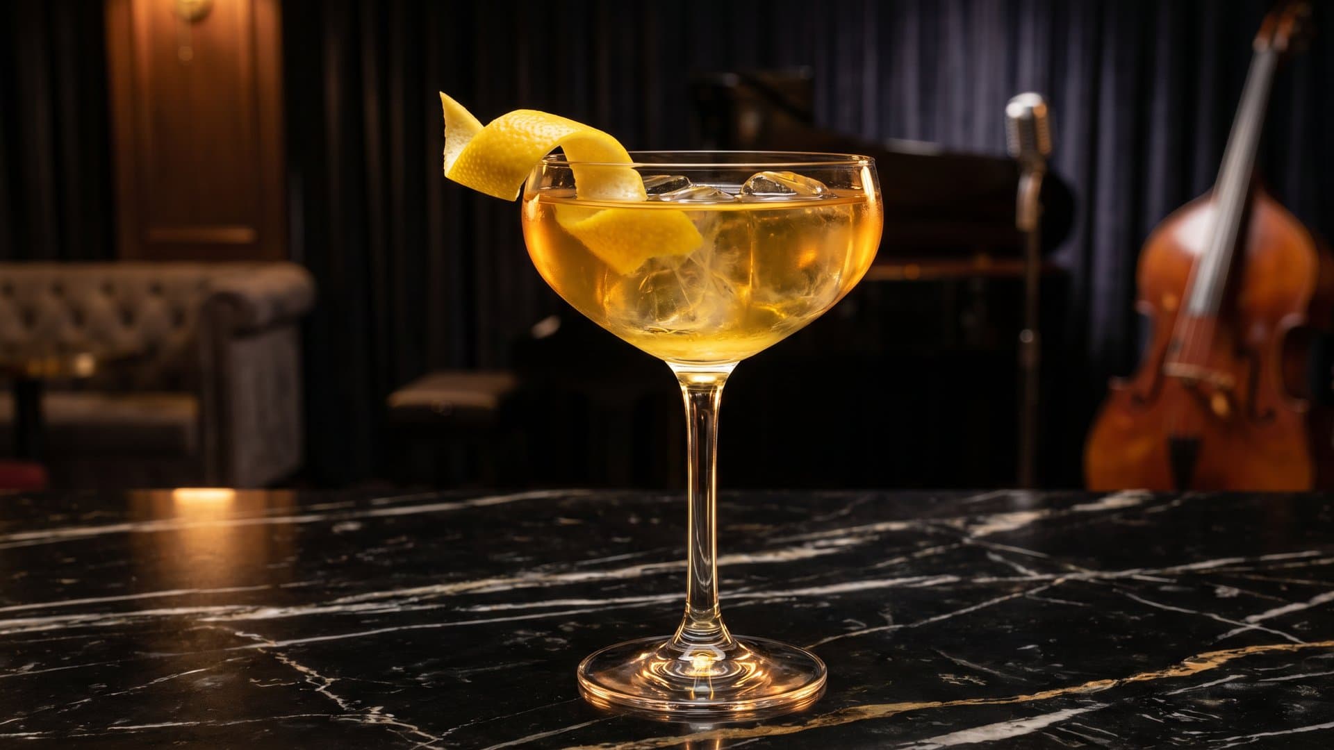 The Gilded Revival cocktail in a coupe garnished with expressed lemon peel