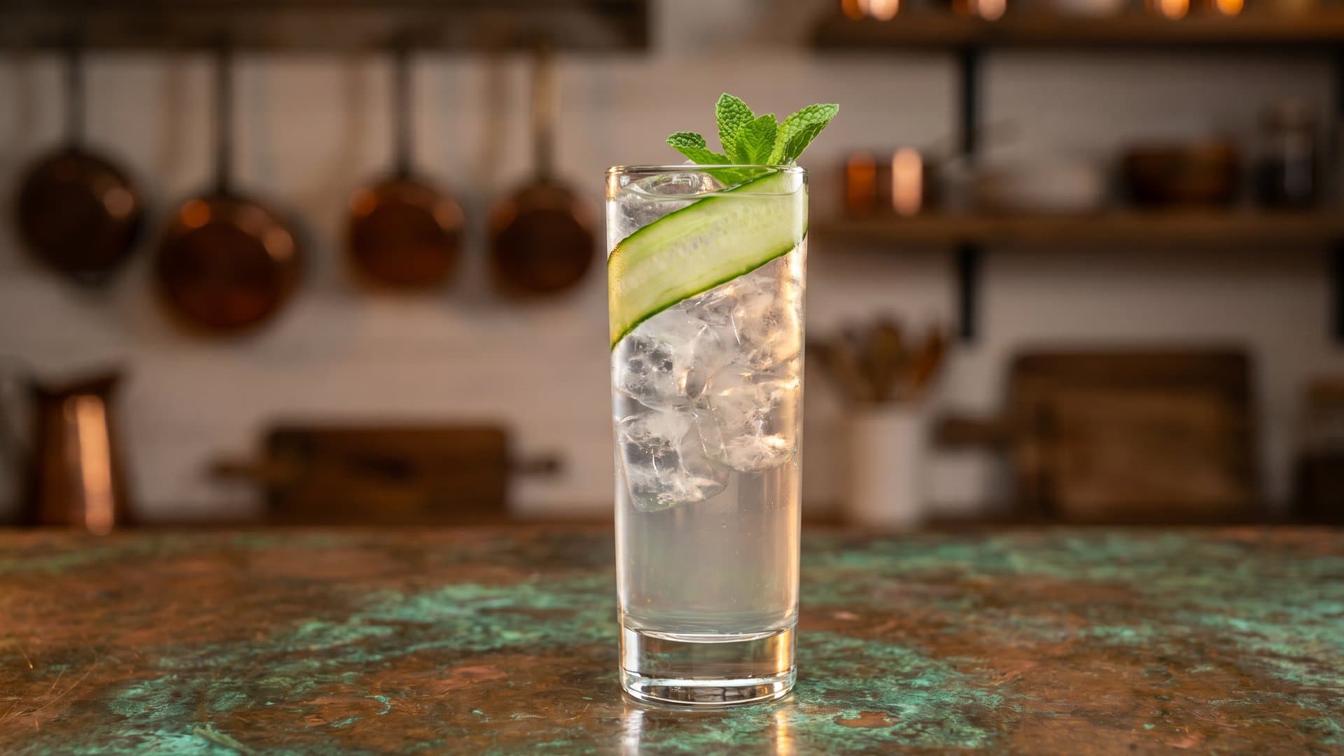 Garden Cooler cocktail in a highball garnished with cucumber ribbon and mint sprig