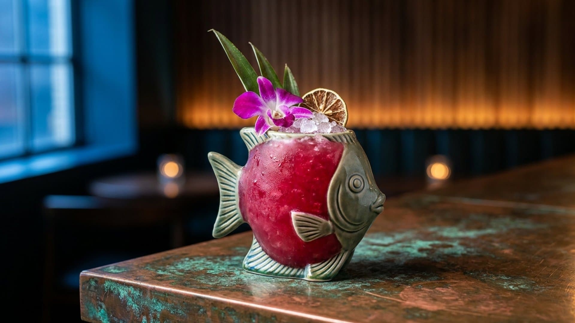 Island Sorcerer cocktail in a tiki mug garnished with pineapple frond, orchid, and lime wheel