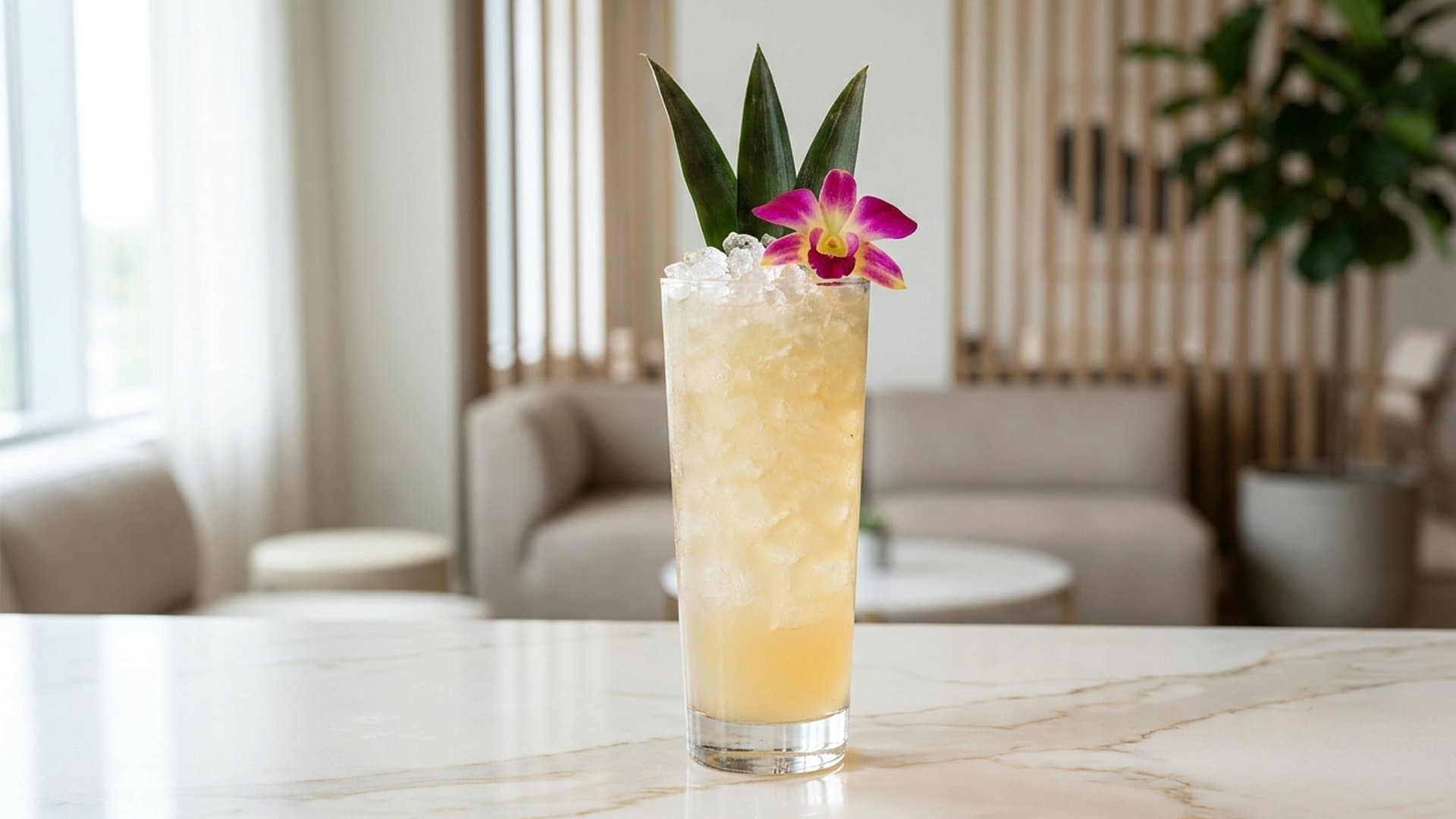 Sunset Lagoon cocktail in a Collins or hurricane garnished with Pineapple fronds and edible flower